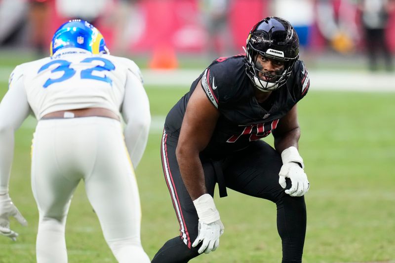 Arizona Cardinals offensive tackle Paris Johnson Jr., right, moves over to block Los Angeles Rams linebacker Ochaun Mathis (32) during the second half of an NFL football game Sunday, Nov. 26, 2023, in Glendale, Ariz. The Rams won 37-14. (AP Photo/Ross D. Franklin)