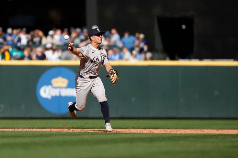 Sep 19, 2024; Seattle, Washington, USA; New York Yankees shortstop Anthony Volpe (11) turns a double play against the Seattle Mariners during the sixth inning at T-Mobile Park. Mandatory Credit: Joe Nicholson-Imagn Images