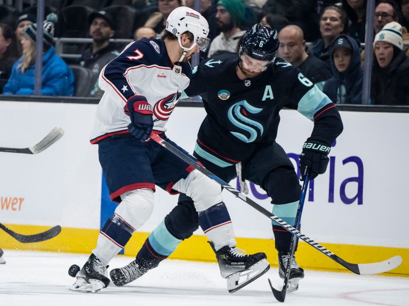 Jan 28, 2024; Seattle, Washington, USA; Seattle Kraken defenseman Adam Larsson (6) and Columbus Blue Jackets forward Sean Kuraly (7) battle for the puck during the first period at Climate Pledge Arena. Mandatory Credit: Stephen Brashear-USA TODAY Sports