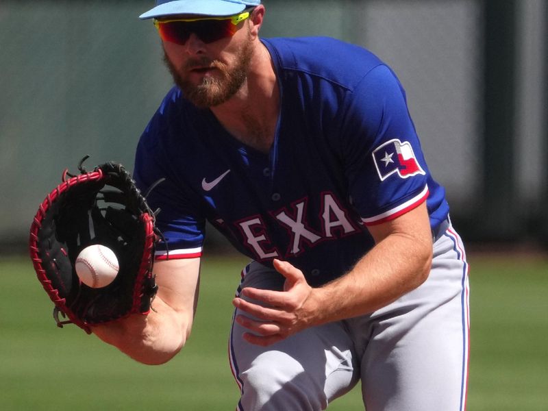 Mar 23, 2024; Surprise, Arizona, USA; Texas Rangers first baseman Jared Walsh (21) fields a ground ball 
against the Kansas City Royals during the fourth inning at Surprise Stadium. Mandatory Credit: Joe Camporeale-USA TODAY Sports