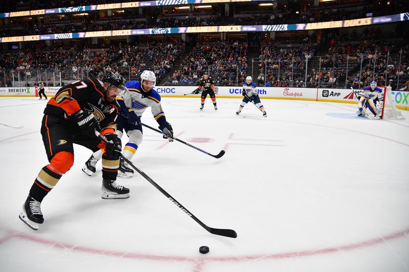 Apr 7, 2024; Anaheim, California, USA; Anaheim Ducks right wing Frank Vatrano (77) moves the puck against St. Louis Blues left wing Brandon Saad (20) during the overtime period at Honda Center. Mandatory Credit: Gary A. Vasquez-USA TODAY Sports