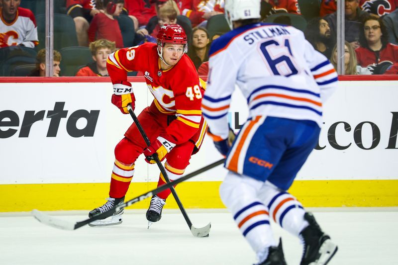 Sep 21, 2025; Calgary, Alberta, CAN; Calgary Flames left wing Andrew Basha (49) controls the puck against the Edmonton Oilers during the second period at Scotiabank Saddledome. Mandatory Credit: Sergei Belski-Imagn Images
