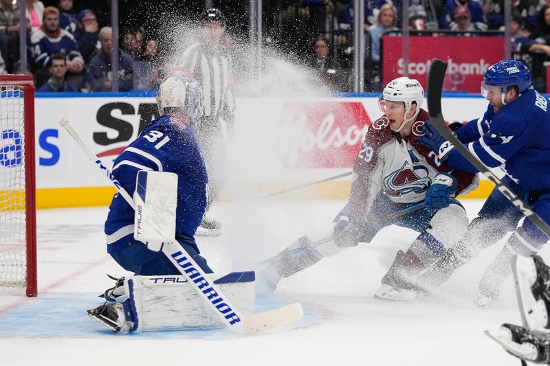 Jan 13, 2024; Toronto, Ontario, CAN; Colorado Avalanche forward Nathan MacKinnon (29) tries to knock in a puck on Toronto Maple Leafs goaltender Martin Jones (31) as Toronto Maple Leafs defenseman Morgan Rielly (44) defends during the second period at Scotiabank Arena. Mandatory Credit: John E. Sokolowski-USA TODAY Sports