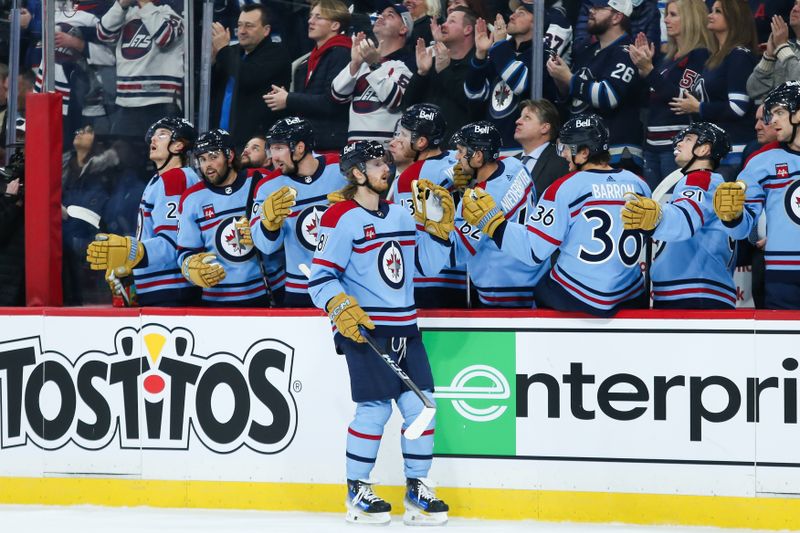 Dec 4, 2023; Winnipeg, Manitoba, CAN; Winnipeg Jets forward Kyle Connor (81) celebrates with teammates after scoring a goal against the Carolina Hurricanes during the first period at Canada Life Centre. Mandatory Credit: Terrence Lee-USA TODAY Sports