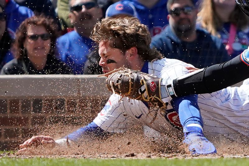 Apr 21, 2024; Chicago, Illinois, USA; Miami Marlins catcher Nick Fortes (4) tags out Chicago Cubs second baseman at home plate during the fourth inning Nico Hoerner (2) at Wrigley Field. Mandatory Credit: David Banks-USA TODAY Sports