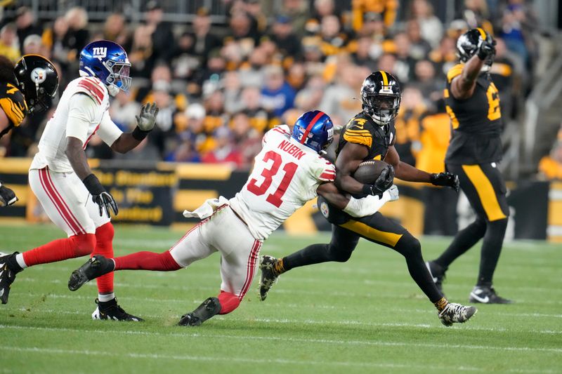 Pittsburgh Steelers wide receiver George Pickens (14) is tackled by New York Giants safety Tyler Nubin (31) during the first half of an NFL football game Monday, Oct. 28, 2024, in Pittsburgh. (AP Photo/Gene J. Puskar)