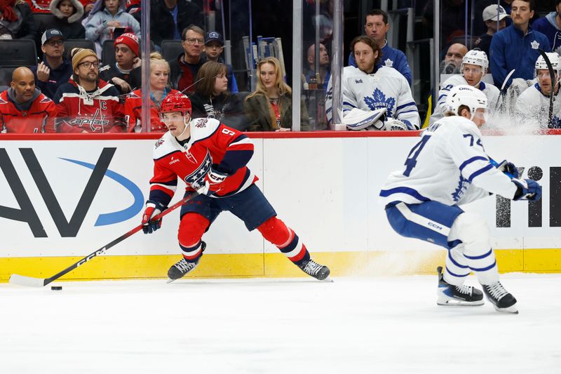 Nov 28, 2025; Washington, District of Columbia, USA; Washington Capitals right wing Ryan Leonard (9) skates with the puck past Toronto Maple Leafs center Bobby McMann (74) during the first period at Capital One Arena. Mandatory Credit: Geoff Burke-Imagn Images