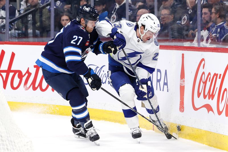 Jan 2, 2024; Winnipeg, Manitoba, CAN; Winnipeg Jets left wing Nikolaj Ehlers (27) and Tampa Bay Lightning center Michael Eyssimont (23) fight for the puck in the first period at Canada Life Centre. Mandatory Credit: James Carey Lauder-USA TODAY Sports