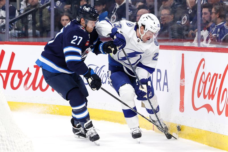 Jan 2, 2024; Winnipeg, Manitoba, CAN; Winnipeg Jets left wing Nikolaj Ehlers (27) and Tampa Bay Lightning center Michael Eyssimont (23) fight for the puck in the first period at Canada Life Centre. Mandatory Credit: James Carey Lauder-USA TODAY Sports