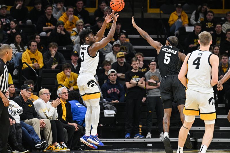 Mar 6, 2025; Iowa City, Iowa, USA; Iowa Hawkeyes guard Drew Thelwell (3) shoots the ball as Michigan State Spartans guard Tre Holloman (5) defends during the first half at Carver-Hawkeye Arena. Mandatory Credit: Jeffrey Becker-Imagn Images