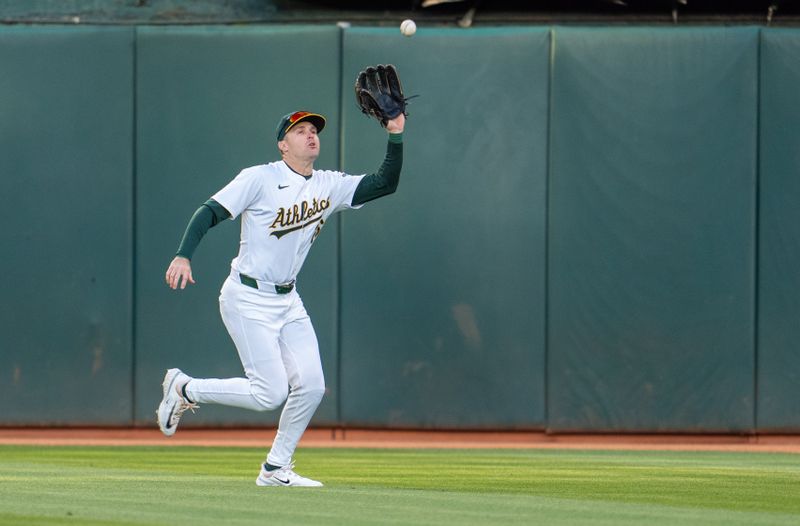 May 6, 2024; Oakland, California, USA; Oakland Athletics outfielder Tyler Nevin (26) fields a fly ball against the Texas Rangers during the third inning at Oakland-Alameda County Coliseum. Mandatory Credit: Neville E. Guard-USA TODAY Sports