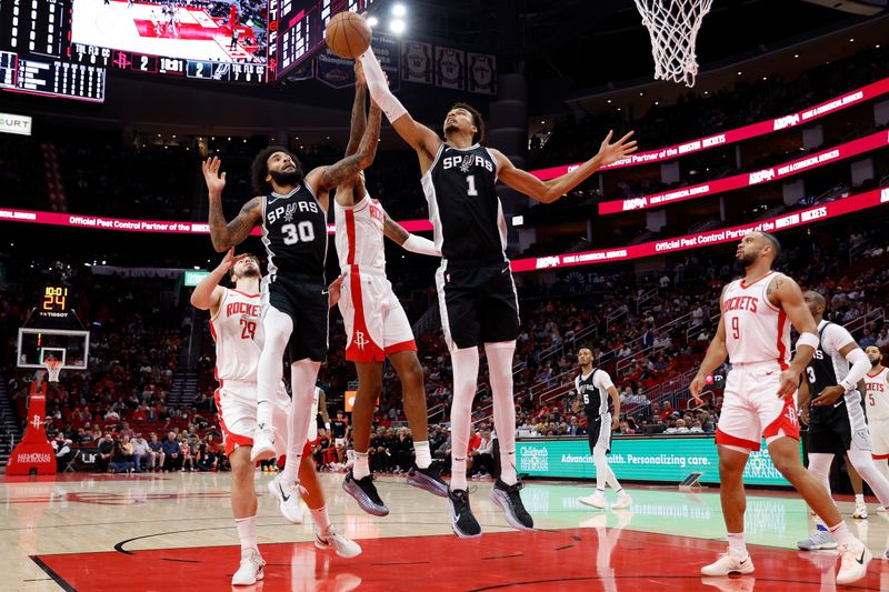 HOUSTON, TEXAS - NOVEMBER 06: Victor Wembanyama #1 of the San Antonio Spurs and Julian Champagnie #30 battle Jabari Smith Jr. #10 of the Houston Rockets for a rebound in the first half at Toyota Center on November 06, 2024 in Houston, Texas.  NOTE TO USER: User expressly acknowledges and agrees that, by downloading and or using this photograph, User is consenting to the terms and conditions of the Getty Images License Agreement.  (Photo by Tim Warner/Getty Images)