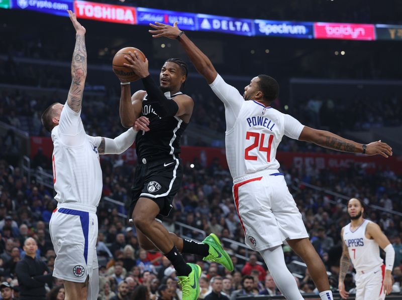 LOS ANGELES, CALIFORNIA - JANUARY 21: Dennis Smith Jr. #4 of the Brooklyn Nets attempts a layup between Daniel Theis #10 and Norman Powell #24 of the LA Clippersduring the first half at Crypto.com Arena on January 21, 2024 in Los Angeles, California. User is consenting to the terms and conditions of the Getty Images License Agreement. (Photo by Harry How/Getty Images)