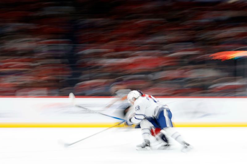 Dec 18, 2025; Washington, District of Columbia, USA;  Toronto Maple Leafs left wing Matthew Knies (23) and Washington Capitals defenseman Declan Chisholm (47) chase the puck during the second periodat Capital One Arena. Mandatory Credit: Geoff Burke-Imagn Images