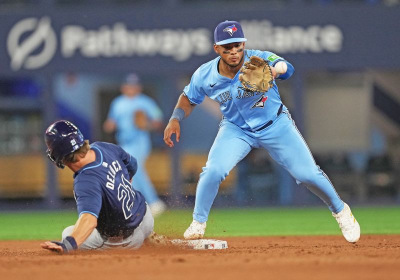 Jul 23, 2024; Toronto, Ontario, CAN; Tampa Bay Rays pinch runner Jonny DeLuca (21) steals second base ahead of the tag from Toronto Blue Jays shortstop Leo Jimenez (49) during the ninth inning at Rogers Centre. Mandatory Credit: Nick Turchiaro-USA TODAY Sports