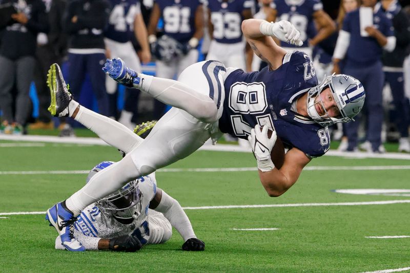 Dallas Cowboys tight end Jake Ferguson (87) is tripped up by Detroit Lions safety Kerby Joseph during the second half of an NFL football game, Saturday, Dec. 30, 2023, in Arlington, Texas. (AP Photo/Michael Ainsworth)