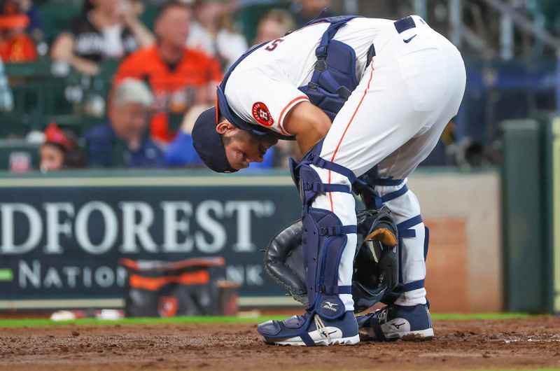 Jun 23, 2024; Houston, Texas, USA; Houston Astros catcher Cesar Salazar (18) reacts after he was  hit in the neck with the ball while Baltimore Orioles shortstop Jorge Mateo (3) (not pictured) bats in the fourth inning at Minute Maid Park. Mandatory Credit: Thomas Shea-USA TODAY Sports