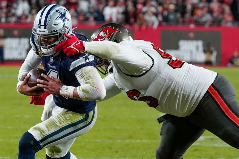 Tampa Bay Buccaneers defensive end Akiem Hicks (96) tries to tackle Dallas Cowboys quarterback Dak Prescott (4) during the first half of an NFL wild-card football game, Monday, Jan. 16, 2023, in Tampa, Fla. (AP Photo/Chris O'Meara)