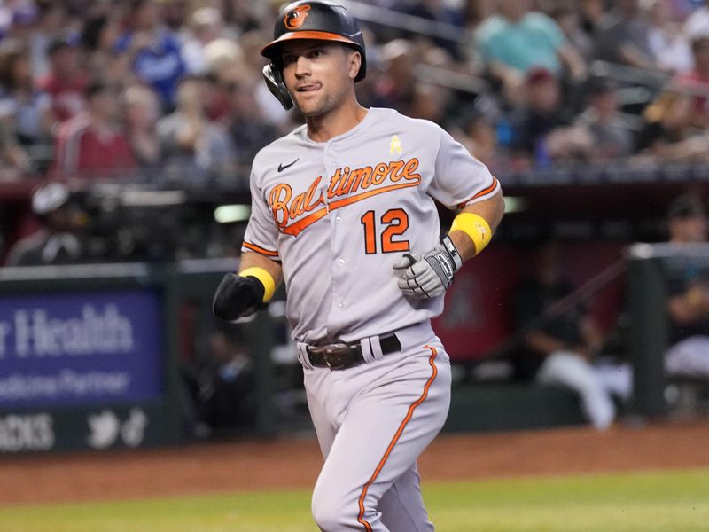 Sep 3, 2023; Phoenix, Arizona, USA; Baltimore Orioles second baseman Adam Frazier (12) scores a run against the Arizona Diamondbacks at Chase Field. Mandatory Credit: Joe Camporeale-USA TODAY Sports