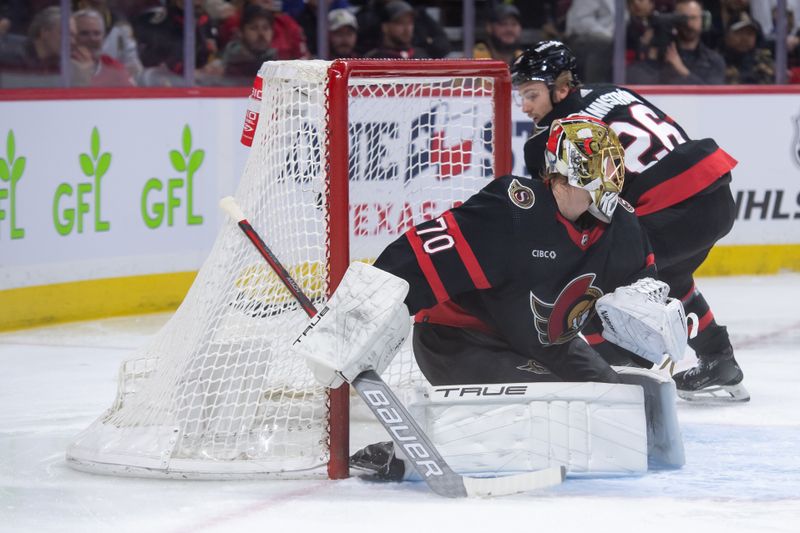 Jan 25, 2024; Ottawa, Ontario, CAN; Ottawa Senators defenseman Erik Brannstrom (26) recovers the puck following a save by goalie Joonas Korpisalo (70) in the second period against the Boston Bruins at Canadian Tire Centre. Mandatory Credit: Marc DesRosiers-USA TODAY Sports