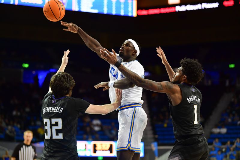 January 14, 2024; Los Angeles, California, USA; UCLA Bruins forward Adem Bona (3) passes the ball against Washington Huskies forward Wilhelm Breidenbach (32) and forward Keion Brooks Jr. (1) during the second half at Pauley Pavilion. Mandatory Credit: Gary A. Vasquez-USA TODAY Sports