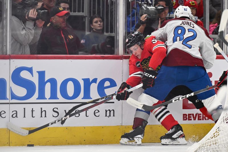 Dec 19, 2023; Chicago, Illinois, USA; Chicago Blackhawks forward MacKenzie Entwistle (58) is pinned to the boards by Colorado Avalanche defenseman Caleb Jones (82) while controlling the puck in the first period at United Center. Mandatory Credit: Jamie Sabau-USA TODAY Sports