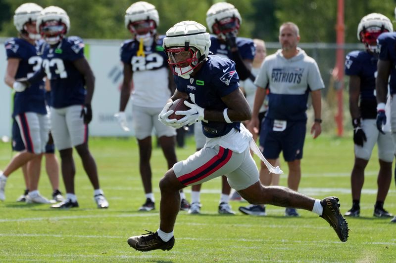 New England Patriots wide receiver Ja'Lynn Polk (1) carries the ball during a joint NFL football practice with the Philadelphia Eagles, Tuesday, Aug. 13, 2024, in Foxborough, Mass. (AP Photo/Michael Dwyer)