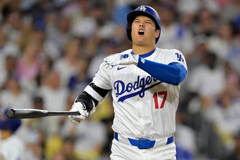 Sep 6, 2024; Los Angeles, California, USA;  Los Angeles Dodgers designated hitter Shohei Ohtani (17) shakes his hand as he reacts after a hitting a foul ball in the third inning against the Cleveland Guardians at Dodger Stadium. Mandatory Credit: Jayne Kamin-Oncea-Imagn Images