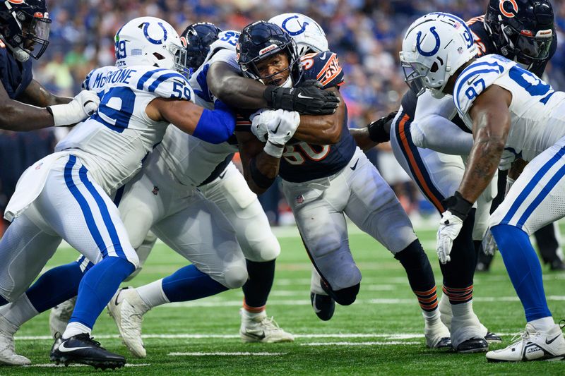 Indianapolis Colts defensive tackle Eric Johnson (93) tackles Chicago Bears running back Roschon Johnson (30) during an NFL football game, Saturday, Aug. 19, 2023, in Indianapolis. (AP Photo/Zach Bolinger)