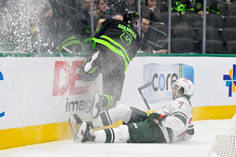 Jan 10, 2024; Dallas, Texas, USA; Dallas Stars defenseman Jani Hakanpaa (2) and Minnesota Wild defenseman Brock Faber (7) chase the puck into the boards during the first period at the American Airlines Center. Mandatory Credit: Jerome Miron-USA TODAY Sports