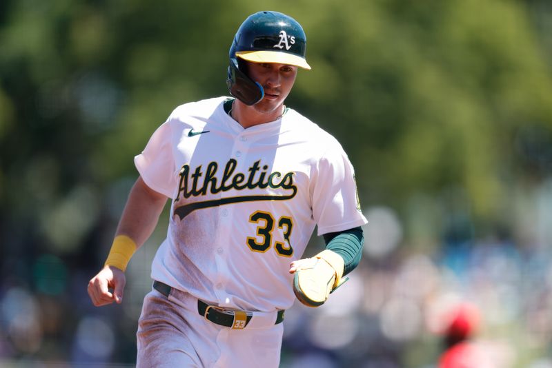 May 22, 2025; West Sacramento, California, USA; Athletics center fielder JJ Bleday (33) advances to third on a failed pick off attempt by Los Angeles Angels starting pitcher Tyler Anderson (31) during the third inning at Sutter Health Park. Mandatory Credit: Sergio Estrada-Imagn Images