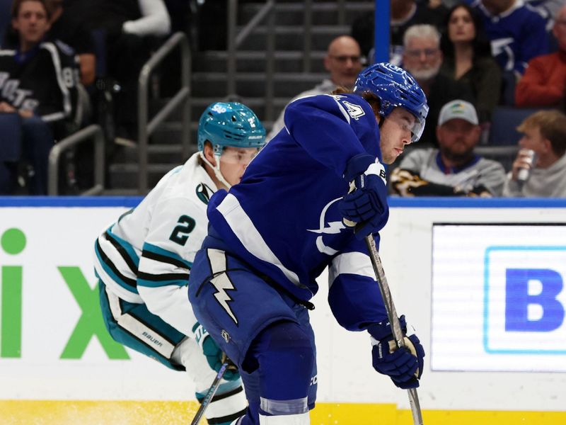 Dec 5, 2024; Tampa, Florida, USA; Tampa Bay Lightning center Conor Geekie (14) shoots and scores a goal as San Jose Sharks center Will Smith (2) defends during the first period at Amalie Arena. Mandatory Credit: Kim Klement Neitzel-Imagn Images