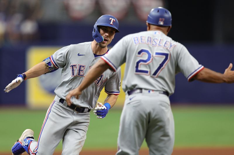 Oct 4, 2023; St. Petersburg, Florida, USA; Texas Rangers left fielder Evan Carter (32) high fives third base coach Tony Beasley (27) after hitting a solo home run against the Tampa Bay Rays in the fourth inning during game two of the Wildcard series for the 2023 MLB playoffs at Tropicana Field. Mandatory Credit: Nathan Ray Seebeck-USA TODAY Sports