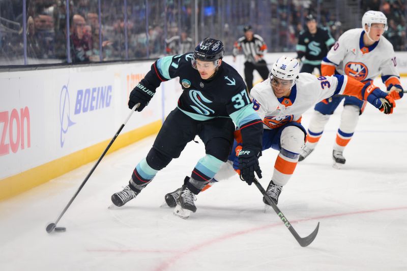 Nov 16, 2024; Seattle, Washington, USA; Seattle Kraken center Yanni Gourde (37) advances the puck while defended by New York Islanders defenseman Isaiah George (36) during the first period at Climate Pledge Arena. Mandatory Credit: Steven Bisig-Imagn Images