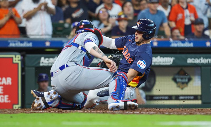 Apr 14, 2024; Houston, Texas, USA; Houston Astros designated hitter Yainer Diaz (21) is tagged out by Texas Rangers catcher Jonah Heim (28) on a play at the plate during the fifth inning at Minute Maid Park. Mandatory Credit: Troy Taormina-USA TODAY Sports