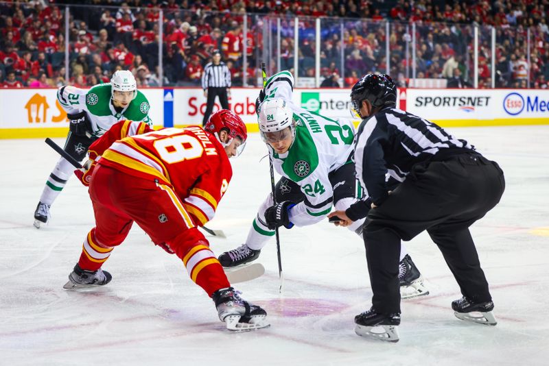 Nov 30, 2023; Calgary, Alberta, CAN; Dallas Stars center Roope Hintz (24) and Calgary Flames center Elias Lindholm (28) face off for the puck during the third period at Scotiabank Saddledome. Mandatory Credit: Sergei Belski-USA TODAY Sports