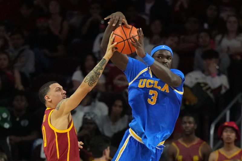 Jan 27, 2024; Los Angeles, California, USA; UCLA Bruins forward Adem Bona (3) and Southern California Trojans guard Kobe Johnson (0) battle for the ball in the second half at Galen Center. Mandatory Credit: Kirby Lee-USA TODAY Sports