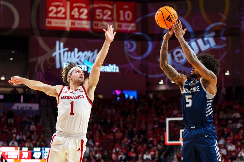 Dec 30, 2025; Lincoln, Nebraska, USA; New Hampshire Wildcats guard R.J. Kennedy (5) shoots against Nebraska Cornhuskers guard Sam Hoiberg (1) during the second half at Pinnacle Bank Arena. Mandatory Credit: Dylan Widger-Imagn Images
