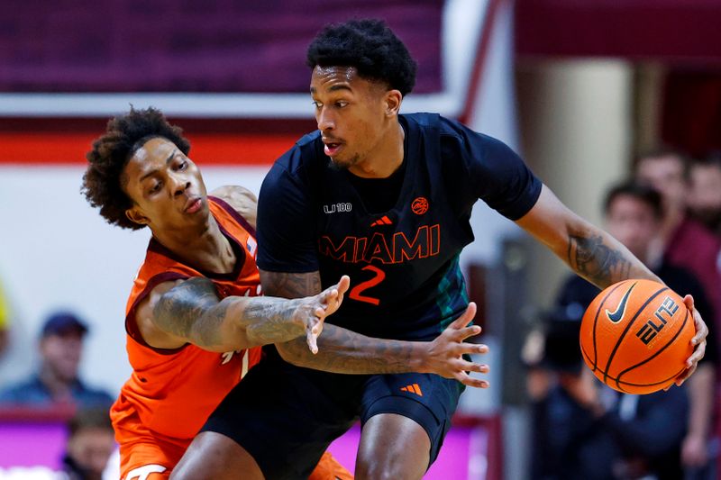 Jan 4, 2025; Blacksburg, Virginia, USA; Miami Hurricanes forward Brandon Johnson (2) handles the ball against Virginia Tech Hokies forward Tobi Lawal (1) during the first half at Cassell Coliseum. Mandatory Credit: Peter Casey-Imagn Images