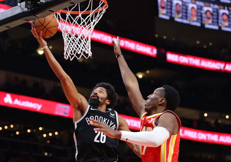 ATLANTA, GEORGIA - DECEMBER 06:  Spencer Dinwiddie #26 of the Brooklyn Nets drives against Onyeka Okongwu #17 of the Atlanta Hawks during the fourth quarter at State Farm Arena on December 06, 2023 in Atlanta, Georgia.  NOTE TO USER: User expressly acknowledges and agrees that, by downloading and/or using this photograph, user is consenting to the terms and conditions of the Getty Images License Agreement.  (Photo by Kevin C. Cox/Getty Images)