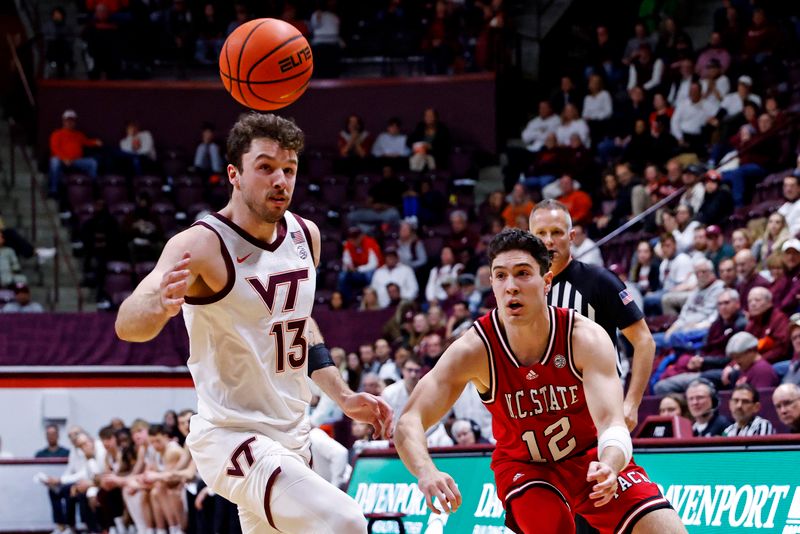 Jan 15, 2025; Blacksburg, Virginia, USA; Virginia Tech Hokies forward Ben Burnham (13) and North Carolina State Wolfpack guard Michael O'Connell (12) watch the ball after Burnham kicked the ball during the second half at Cassell Coliseum. Mandatory Credit: Peter Casey-Imagn Images