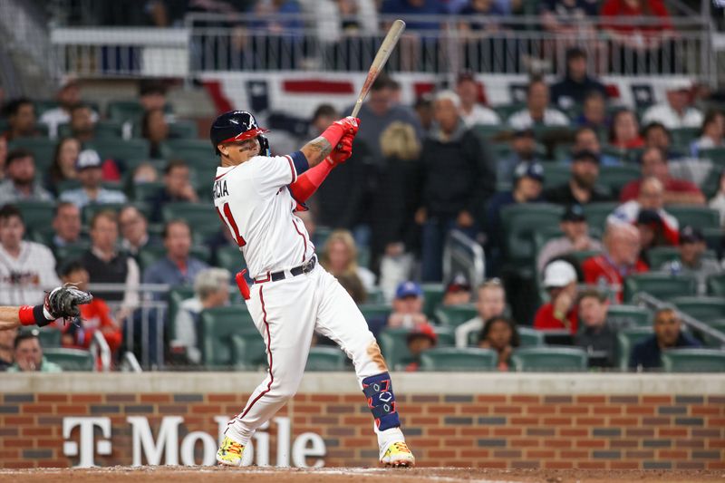 Apr 11, 2023; Atlanta, Georgia, USA; Atlanta Braves shortstop Orlando Arcia (11) hits a RBI single against the Cincinnati Reds in the fifth inning at Truist Park. Mandatory Credit: Brett Davis-USA TODAY Sports
