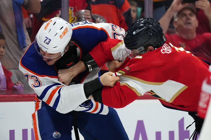 Nov 20, 2023; Sunrise, Florida, USA; Edmonton Oilers defenseman Vincent Desharnais (73) and Florida Panthers left wing Jonah Gadjovich (12) fight during the second period at Amerant Bank Arena. Mandatory Credit: Jasen Vinlove-USA TODAY Sports