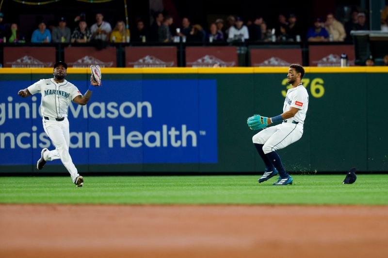 May 31, 2025; Seattle, Washington, USA; Seattle Mariners left fielder Randy Arozarena (56) catches a fly ball in front of center fielder Julio Rodríguez (44) against the Minnesota Twins during the second inning at T-Mobile Park. Mandatory Credit: Joe Nicholson-Imagn Images