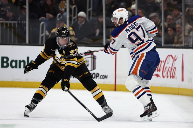 Dec 18, 2025; Boston, Massachusetts, USA; Boston Bruins defenseman Charlie McAvoy (73) breaks up a pass by Edmonton Oilers center Connor McDavid (97) during the first period at TD Garden. Mandatory Credit: Winslow Townson-Imagn Images