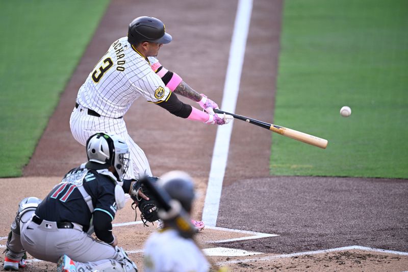 Jul 6, 2024; San Diego, California, USA; San Diego Padres third baseman Manny Machado (13) hits an RBI single against the Arizona Diamondbacks during the first inning at Petco Park. Mandatory Credit: Orlando Ramirez-USA TODAY Sports