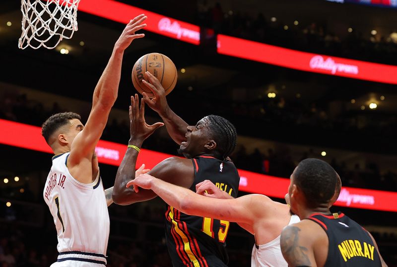 ATLANTA, GEORGIA - DECEMBER 11:  Michael Porter Jr. #1 defends Clint Capela #15 of the Atlanta Hawks draws a foul from Nikola Jokic #15 of the Denver Nuggets during the fourth quarter at State Farm Arena on December 11, 2023 in Atlanta, Georgia.  NOTE TO USER: User expressly acknowledges and agrees that, by downloading and/or using this photograph, user is consenting to the terms and conditions of the Getty Images License Agreement.  (Photo by Kevin C. Cox/Getty Images)