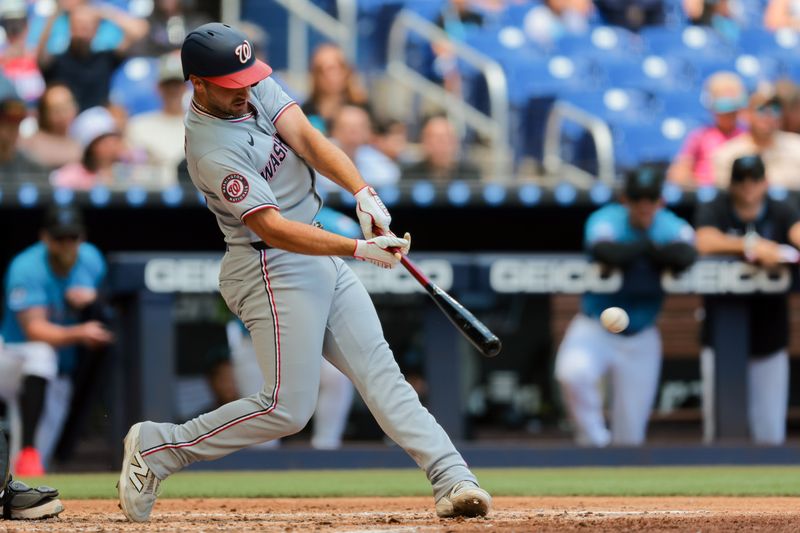 Apr 13, 2025; Miami, Florida, USA; Washington Nationals shortstop Paul DeJong (14) hits an RBI single against the Miami Marlins during the fourth inning at loanDepot Park. Mandatory Credit: Sam Navarro-Imagn Images