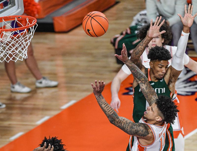 Feb 4, 2023; Clemson, South Carolina, USA; Clemson guard Brevin Galloway (11) shoots near Miami guard Bensley Joseph (4) during the first half at Littlejohn Coliseum in Clemson, S.C. Saturday, Feb. 4, 2023.  Mandatory Credit: Ken Ruinard-USA TODAY Sports