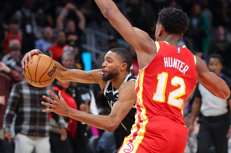 ATLANTA, GEORGIA - DECEMBER 06:  Mikal Bridges #1 of the Brooklyn Nets drives against De'Andre Hunter #12 of the Atlanta Hawks prior to shooting what ends up being the game-winning basket during the fourth quarter at State Farm Arena on December 06, 2023 in Atlanta, Georgia.  NOTE TO USER: User expressly acknowledges and agrees that, by downloading and/or using this photograph, user is consenting to the terms and conditions of the Getty Images License Agreement.  (Photo by Kevin C. Cox/Getty Images)